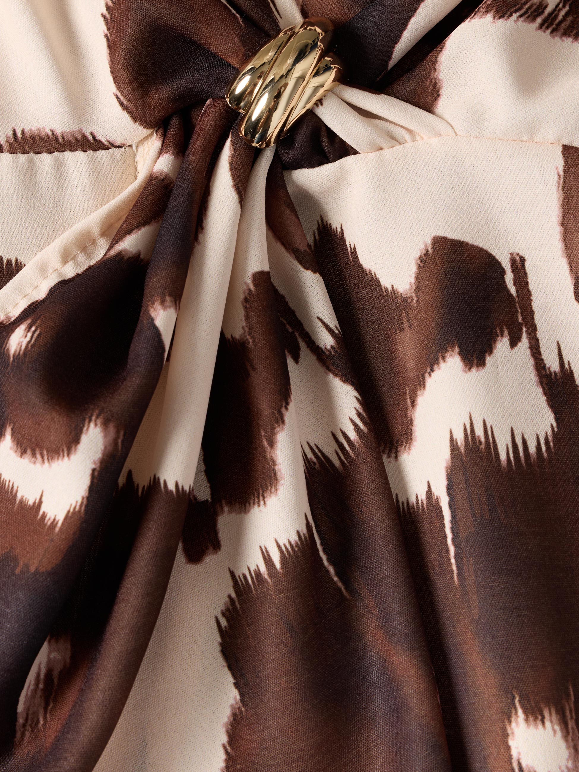 Vestido estampado com broche