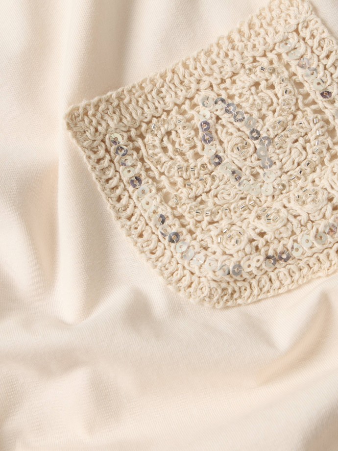 T-shirt com bolso em crochet e lantejoulas