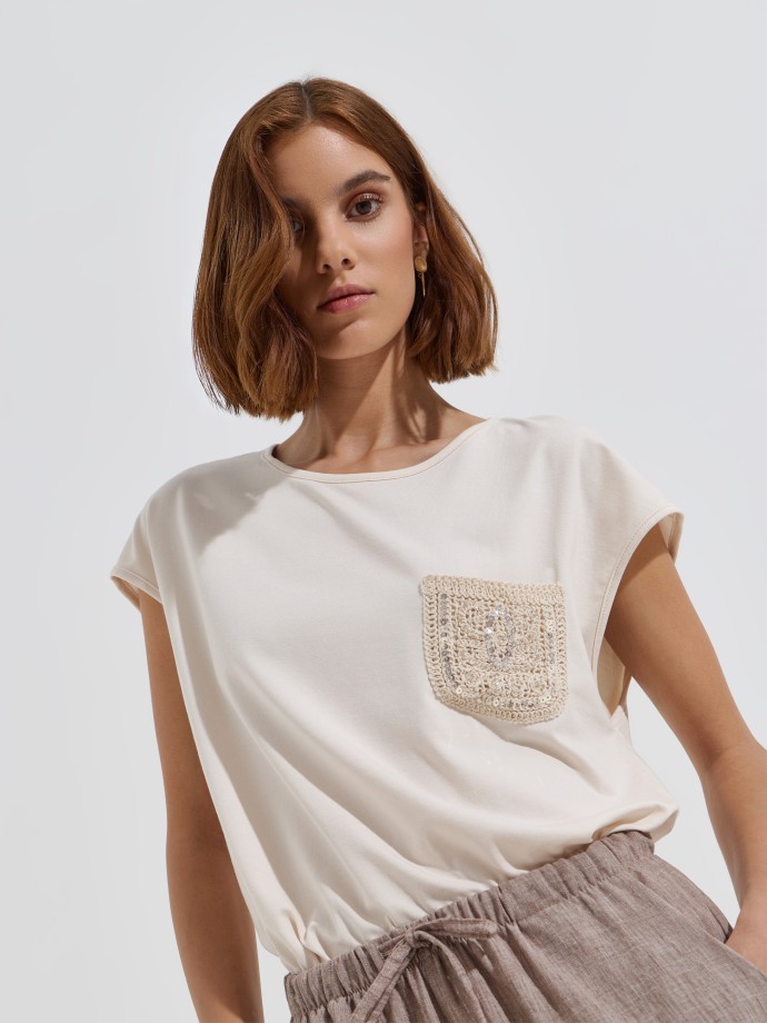 T-shirt com bolso em crochet e lantejoulas